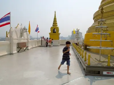 A child runs around the golden stupa on top of Wat Saket, Bangkok