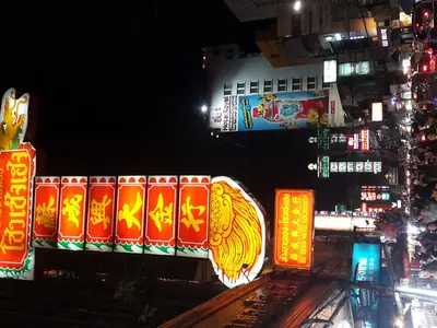 Illuminated vertical goldsmith sign on Yaowarat Road at night