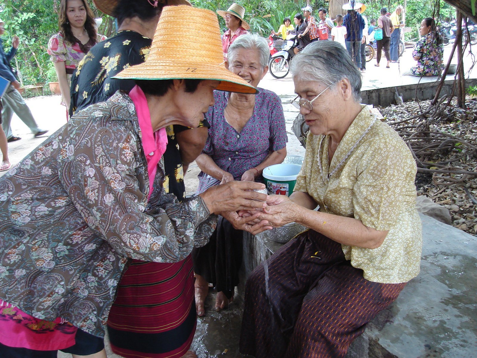Songkran at Wat Kungthapao: a younger person pours water over an elderly woman as a sign of respect (photo: เทวประภาส มากคล้าย, CC BY 3.0, Wikimedia Commons)