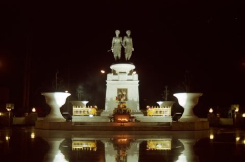 Het Heldinnenmonument in Phuket 's nachts: beelden van de twee heldinnen op een voetstuk met verlichte omgeving