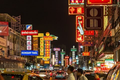 Yaowarat Road (Chinatown Bangkok) bij nacht, vol rode en gele neonborden en drukte - de straat waar het Vegetarische Festival plaatsvindt