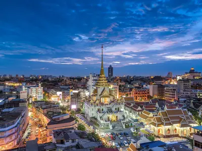 Verlichte tempel boven Chinatown bij nacht, Wat Traimit