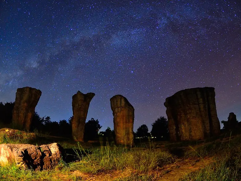 The Milky Way is visible over Mo Hin Khao rock formation in Phu Laenkha National Park, Chaiyaphum, Thailand