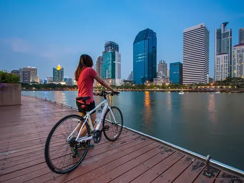 A woman with a bicycle at Benchakitti Park in Bangkok