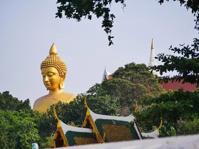 Giant seated golden Buddha above the temple roofs, Wat Paknam Bhasicharoen