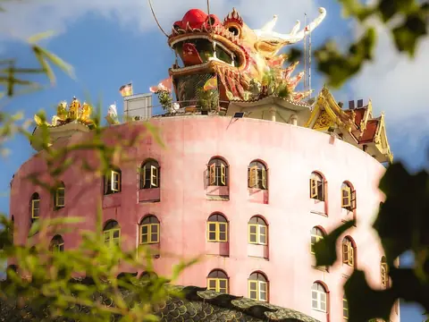 Pink cylindrical tower with a coiling dragon, Wat Samphran